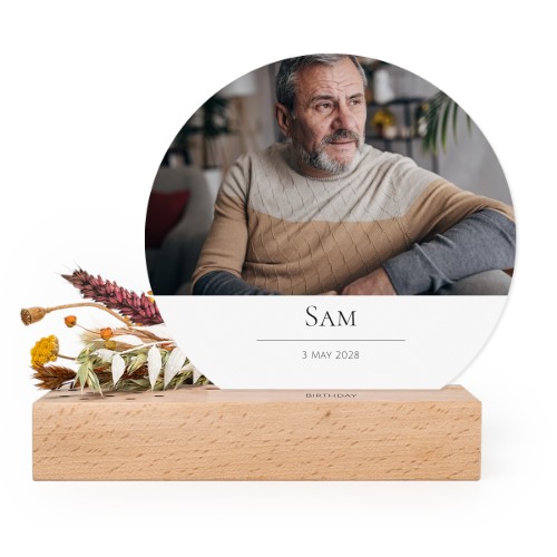 Wooden block with print, dried flowers and rounded forex card