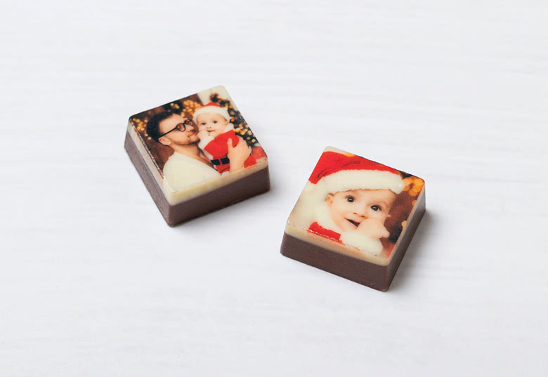 Carrés de calendrier de l'Avent chocolat personnalisés avec des images imprimées d'enfants en tenues festives sur un fond blanc.