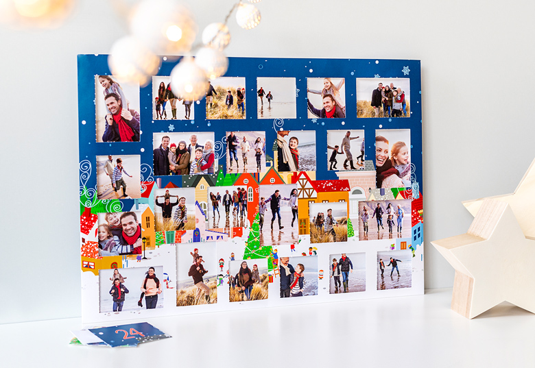 Personalised photo advent calendar with a festive village design, featuring numbered doors and customisable photo windows on a blue background.