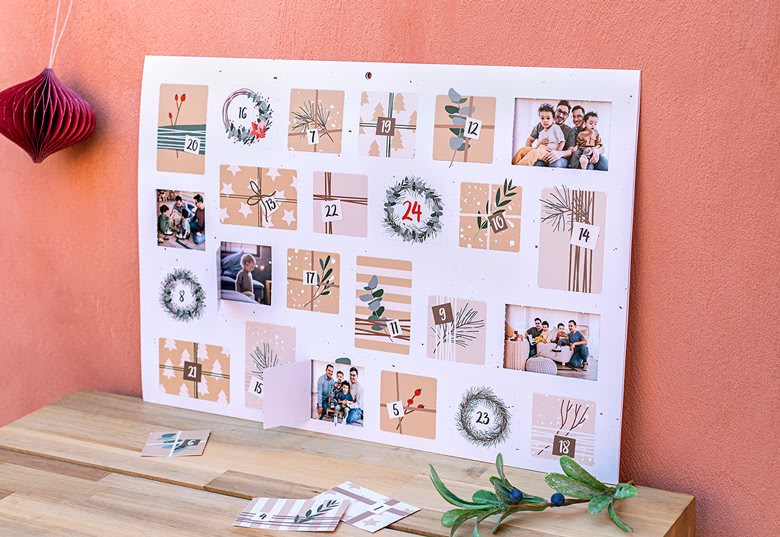 Calendrier de l'Avent photos personnalisé avec un design beige et blanc comprenant des illustrations sur le thème de la nature et des photos de famille derrière chaque porte.