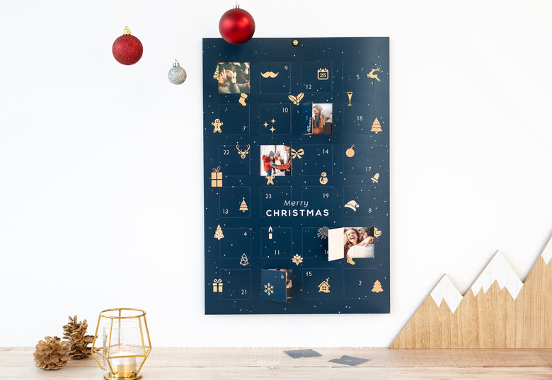 Blue photo advent calendar with customisable photo windows, gold festive icons, and "Merry Christmas" text in white.