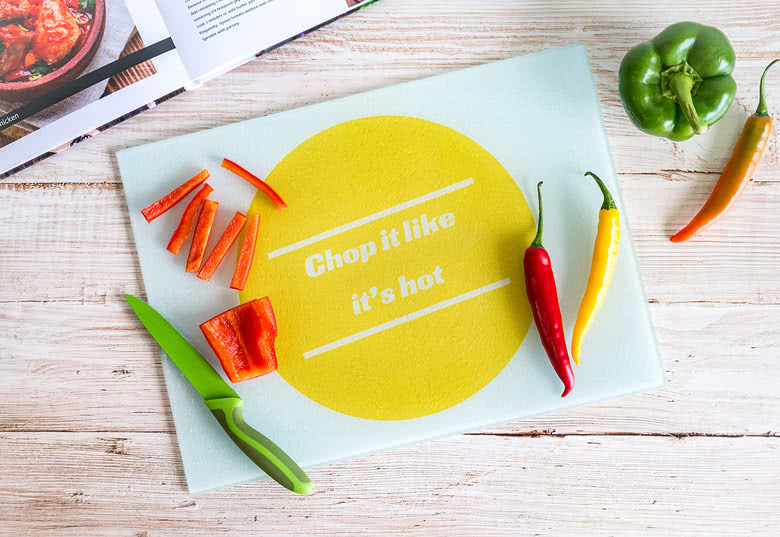 Personalised cutting board with a large yellow circle and the text "Chop it like it's hot" on a light background.