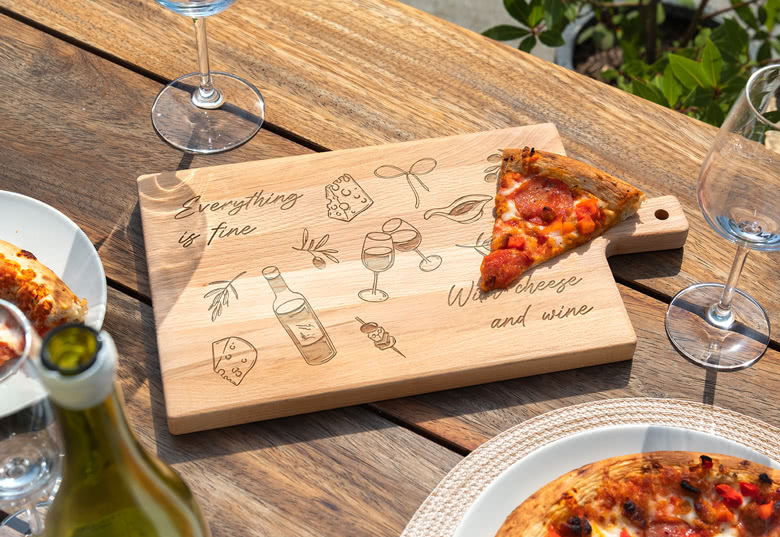 Three round wooden cutting boards with handles, each personalised with different engraved texts, surrounded by food items.