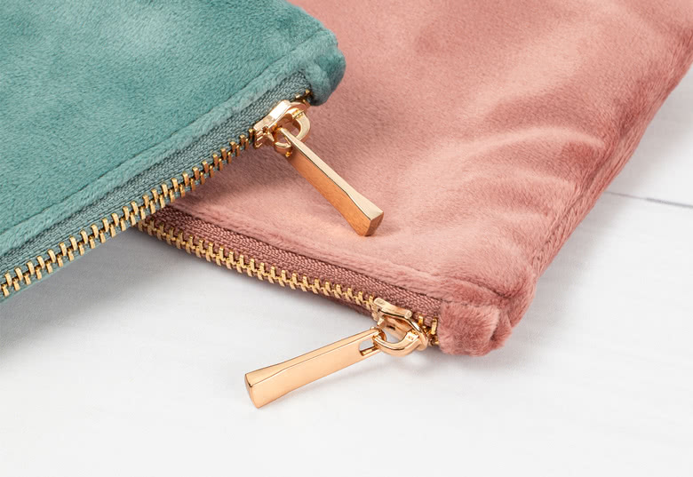 Velour toiletry bags in greenand pink with gold zippers, showcasing a soft texture and elegant personalisation options.