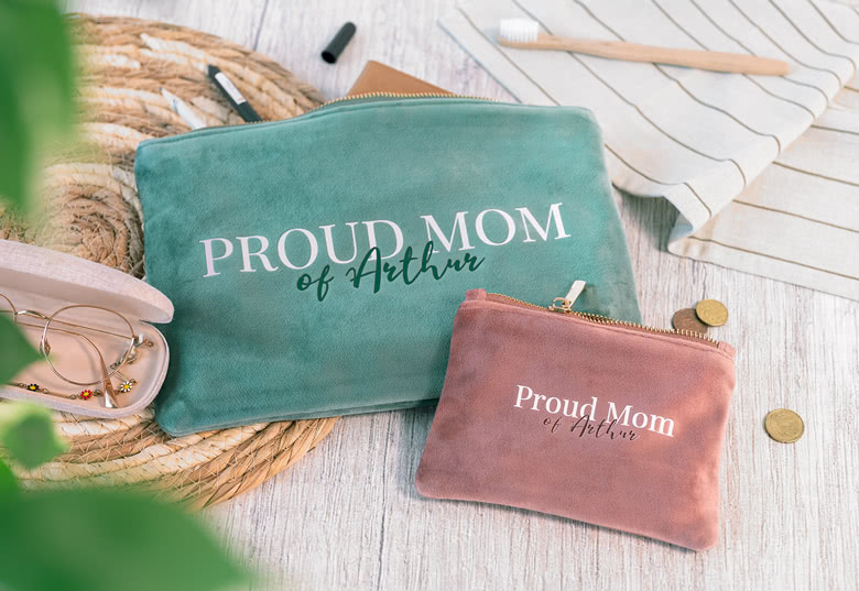 Deux trousses de toilette en velours vert et rose avec le texte "Proud Mom of Arthur", dotées de fermetures éclair dorées, personnalisées et élégantes.