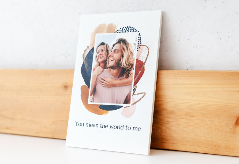 Personalised photo card with a colourful abstract background, featuring a couple's photo and the text "You mean the world to me".