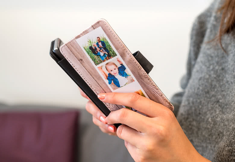 Personalised Samsung wallet case with photos of a family on a personalised background, held by a person.