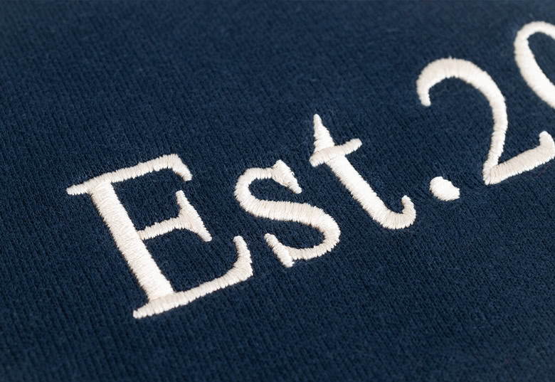 Marineblauwe kindersweater met wit geborduurde tekst "Est. 20XX".