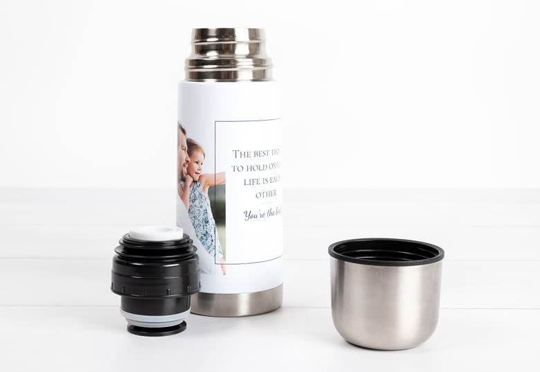 Personalised thermos with a photo and text, featuring a silver cup and black lid. The image shows a woman and a child embracing.