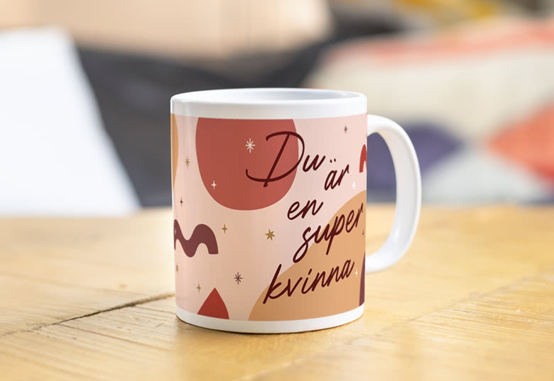Personlig mugg med rosa och brun modern design och texten "Du är en super kvinna" på framsidan.